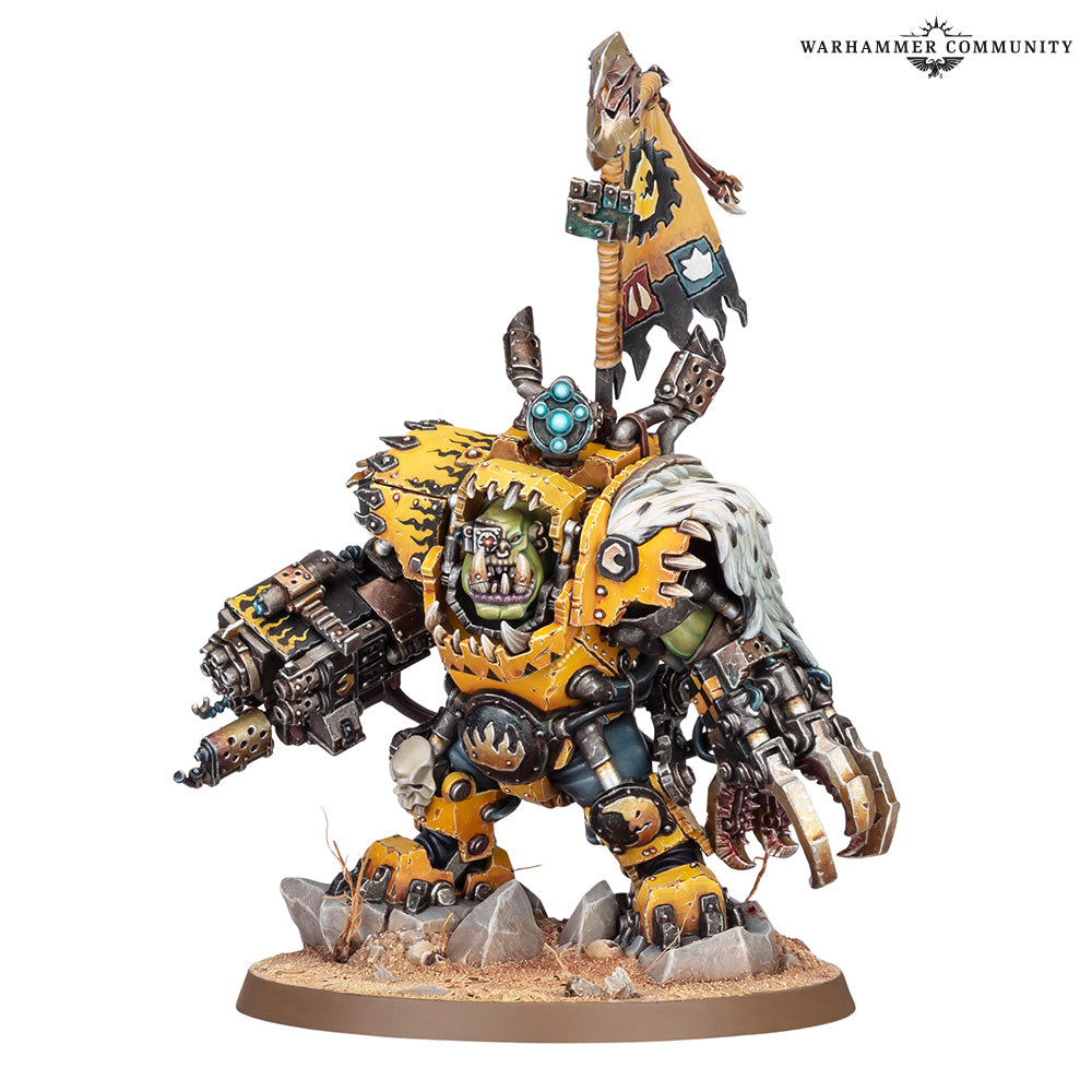 A painted Warhammer 40k Ork miniature on a white background, featuring a yellow and green goblin-like warrior with a white-haired dog on its back, wielding a large gun and carrying a flag.